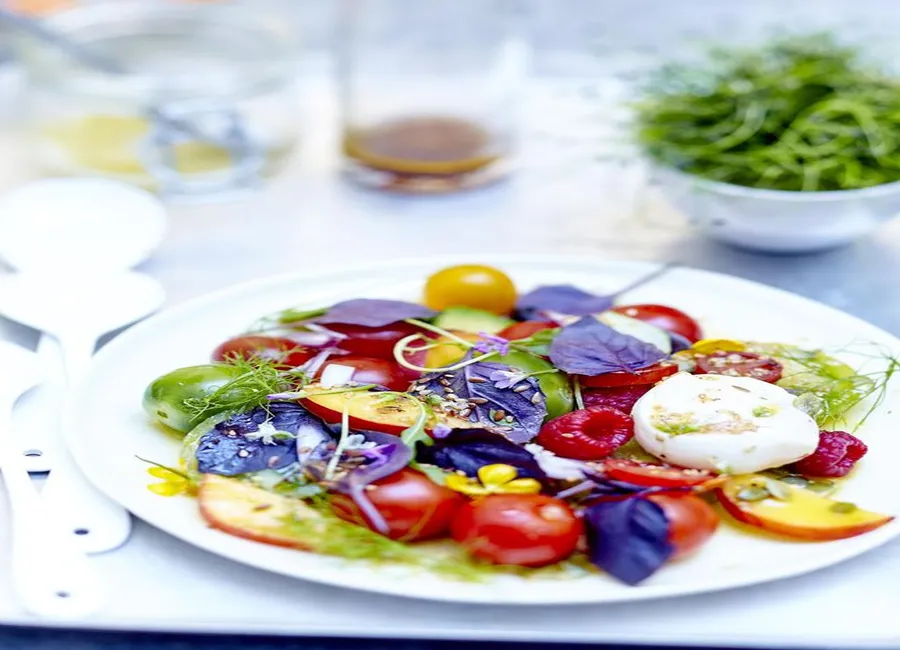 Salade de tomates, fruits, fleurs et burrata au basilic pourpre