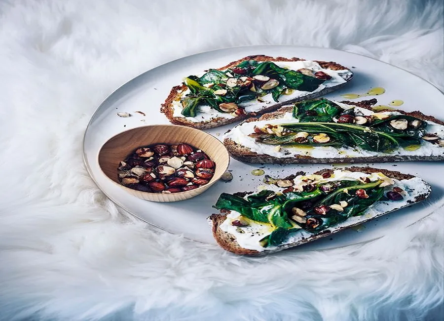 Tartines de pain paysan à la ricotta, aux blettes et aux noisettes grillées