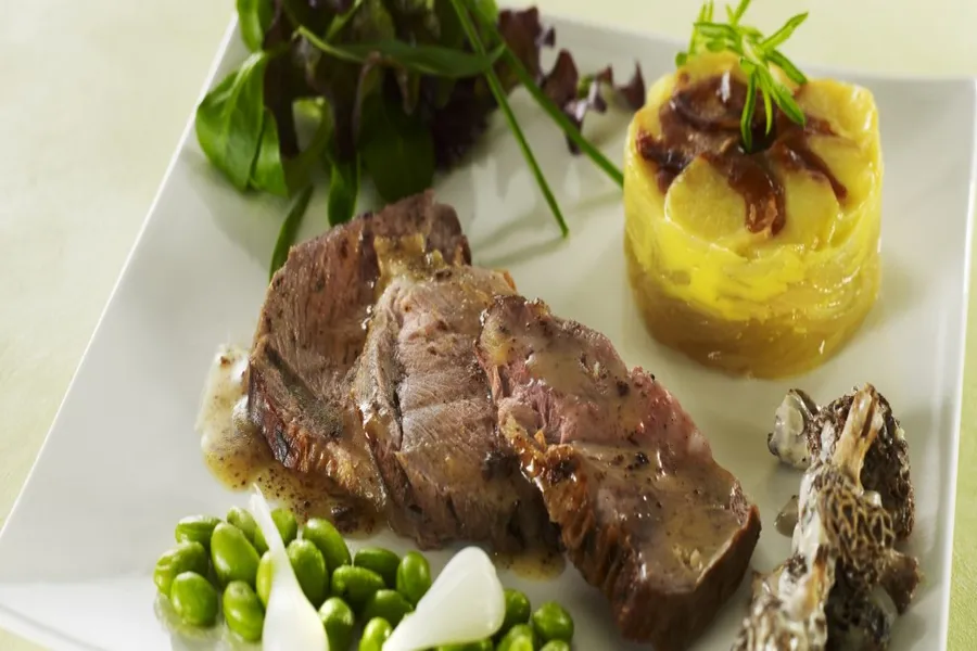 Gigot d'agneau de lait, jus à la sarriette, févettes et petites morilles crémées, herbes pastorale et pommes boulangères