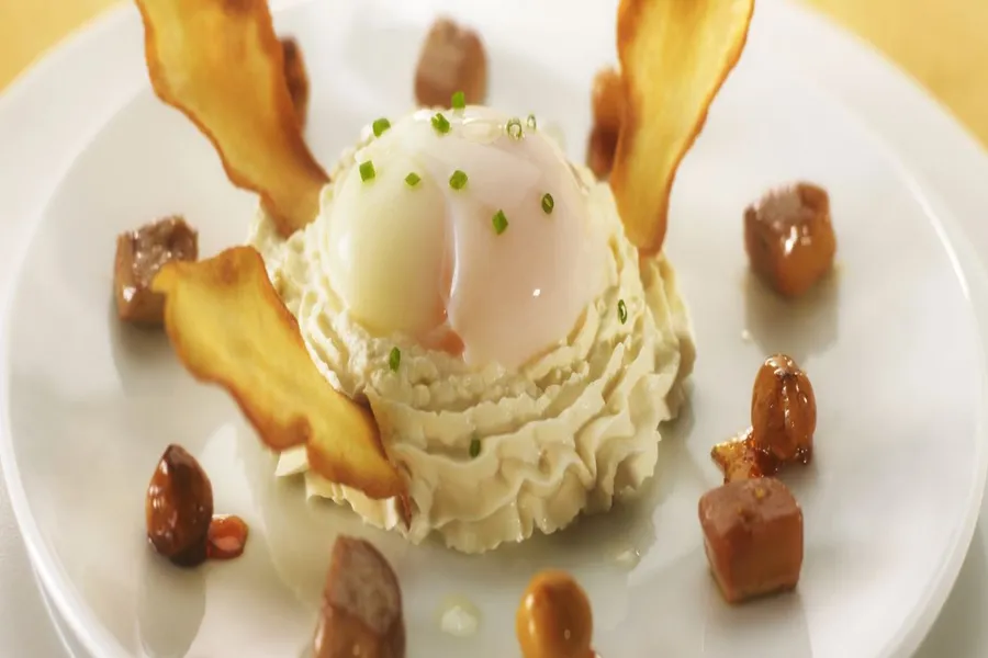 L'œuf de poule cuit nacré, sur une mousseline de topinambours caramélisé au jus, foie gras et noisettes du piémont