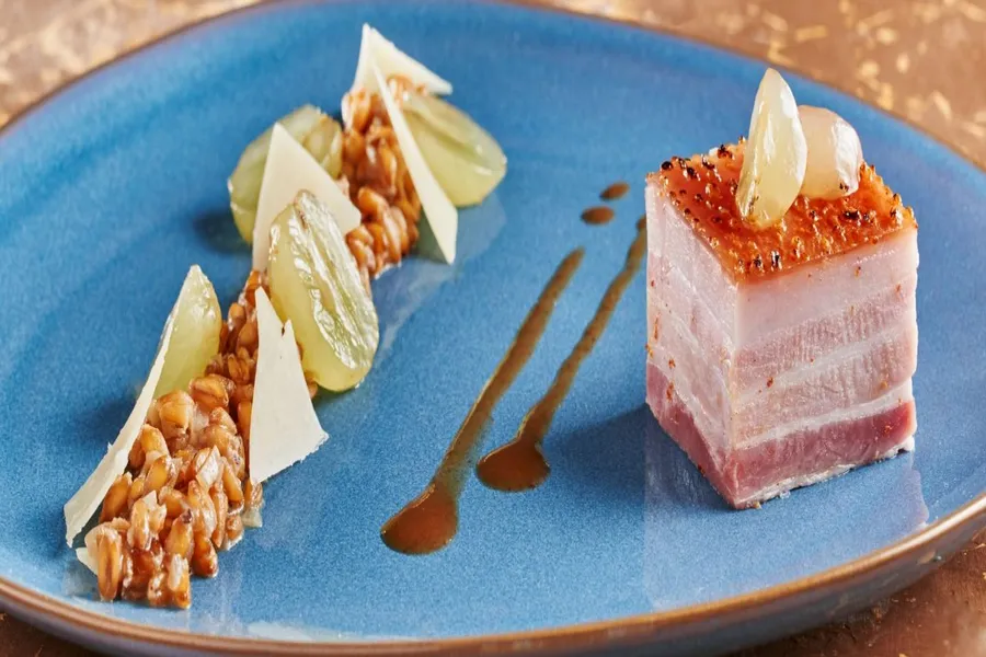 La poitrine de cochon confite, épeautre, raisin et roquette