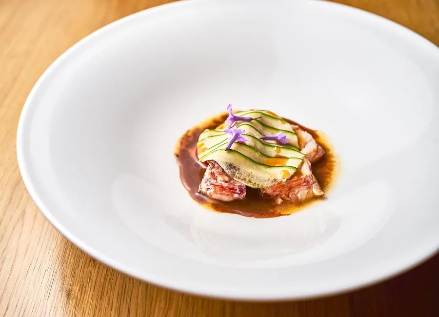 Homard bleu, raviole ouverte de courgette et sauce cacao amer
