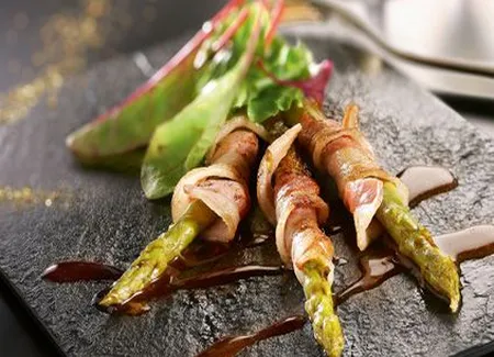 Asperges roulées à la ventrêche de cochon et mesclun de salades