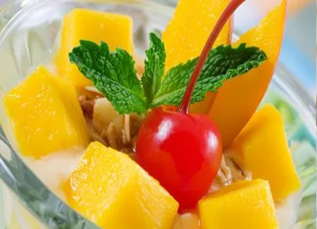 Coupe de cerises rouges et de mangue au miel