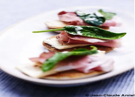 Petits blinis au sarrasin, jambon fumé, pousses d'épinards et munster