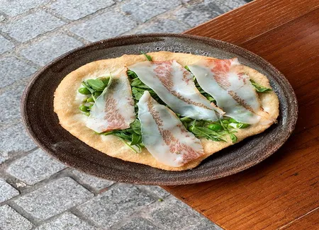 Pizza fritta au stracchino, petits pois et guanciale
