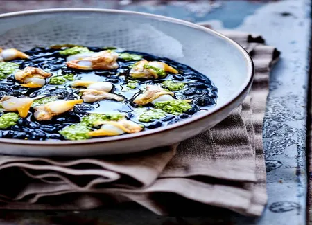 Risotto à l'encre de seiche, pistou et coques