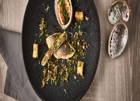 Bar de ligne rôti, couteaux gratinés et ormeaux juste poêlés, cannellonis végétaux à l'huile de sésame, algues en condiments