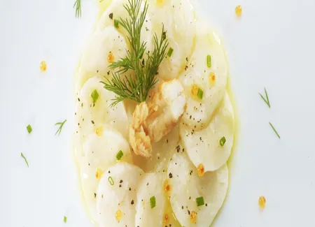 Carpaccio de saint-jacques crue, mariné à l'huile d'olive, citron et langoustine