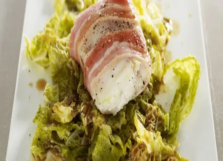 Filet de bar au lard d'arnad, embeurrée de chou vert, jus de poulet