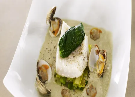 Pavé de bar et huître en habit vert sur une fondue de poireaux, bouillon léger et iodé