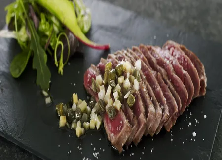 Pièce de bœuf poêlée, servie en fines tranches, vinaigrette échalote parmesan, câpres