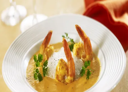 Velouté de carottes parfumé à l'orange, crevettes au curry et espuma de lait de coco