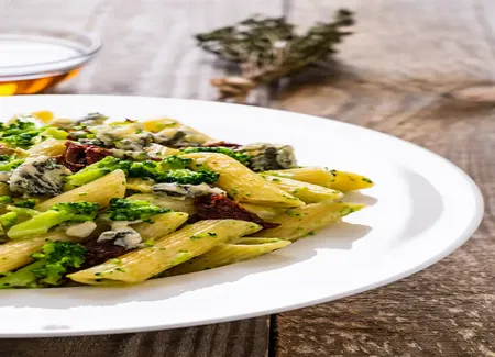 Penne sauce onctueuse brocoli, tomates séchées, noix et roquefort papillon