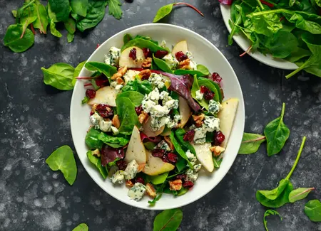 Salade saint agur, cranberries, poires, légumes verts, noix et quinoa