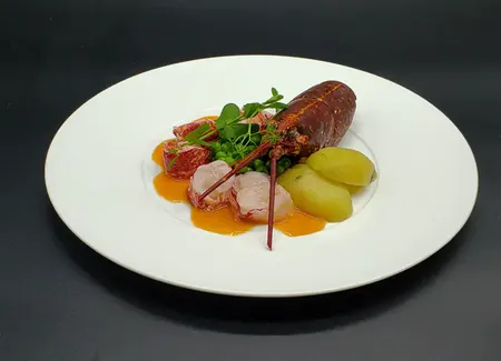 Homard, pommes de terre fondantes, petits pois, shiso pourpre, sauce américaine