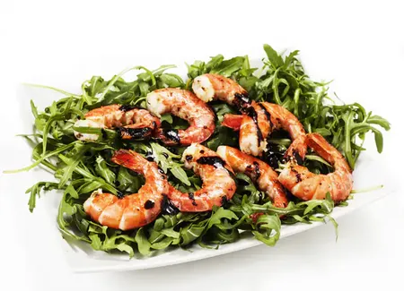 Brochette de gambas sur lit de roquette